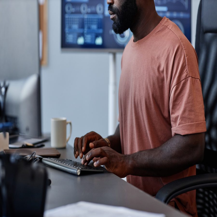 Cropped shot of black man as software developer using computer in high technology office